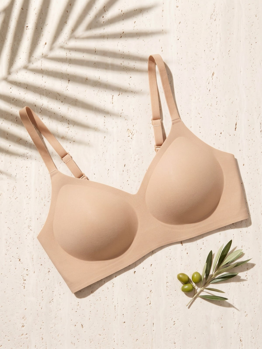 Kiri Charlotte Nude wireless bra on pale travertine with palm shadow