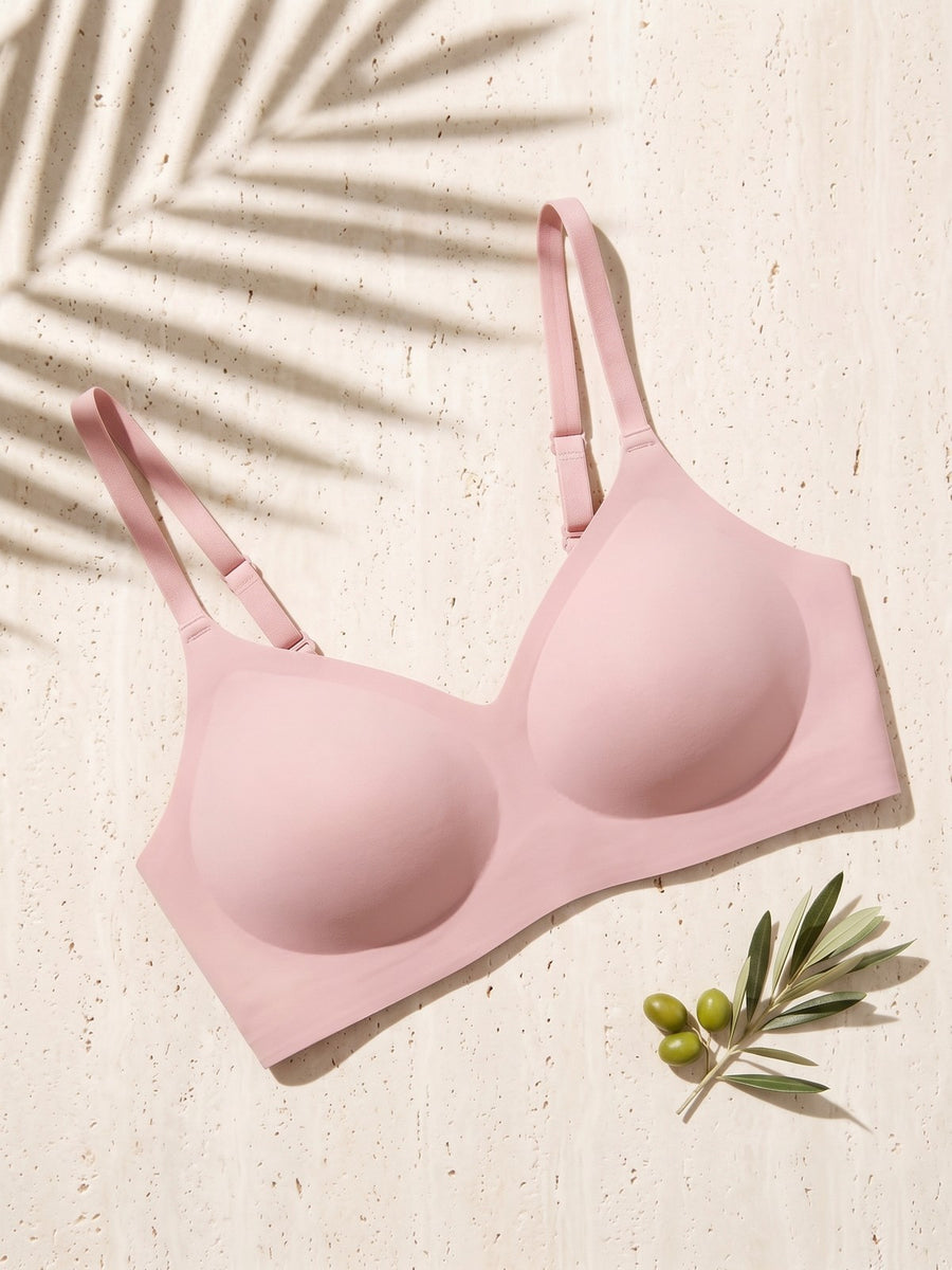Kiri Heather Pink wireless bra on pale travertine with palm shadow