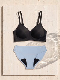 Kiri Selene Black bra with Celeste Blue daywear period underwear as a set on travertine 5