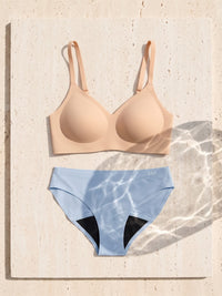Kiri Charlotte Nude bra with Celeste Blue daywear period underwear as a set on travertine 1