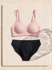Kiri Heather Pink bra with Nisha Black daywear period underwear as a set on travertine 5