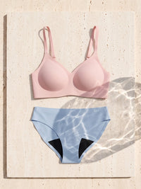 Kiri Heather Pink bra with Celeste Blue daywear period underwear as a set on travertine 1