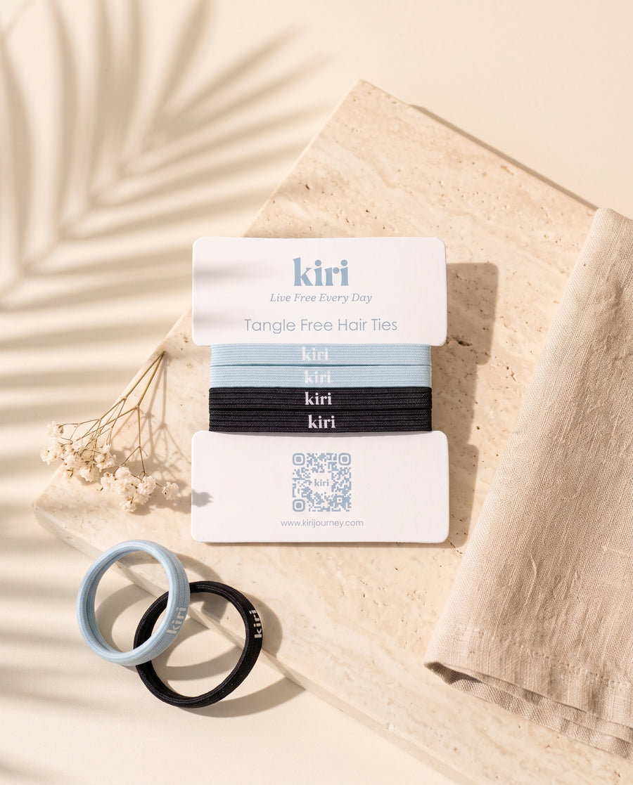 Kiri 防缠结发圈卡放在石灰华石上，旁有亚麻布和干花