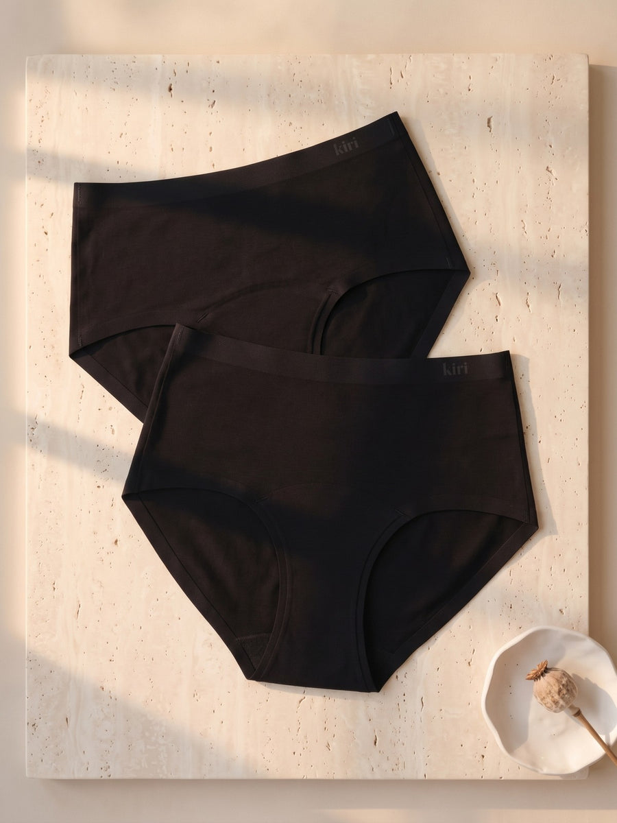 Nightwear Panties Duo: two Selene Black nightwear briefs, front view, on travertine