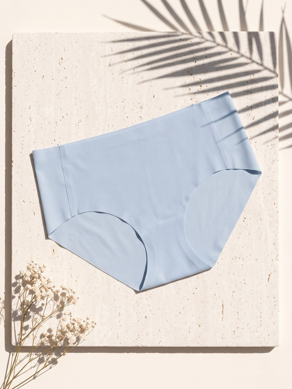 Kiri Celeste Blue daily mid-waist panty on pale travertine